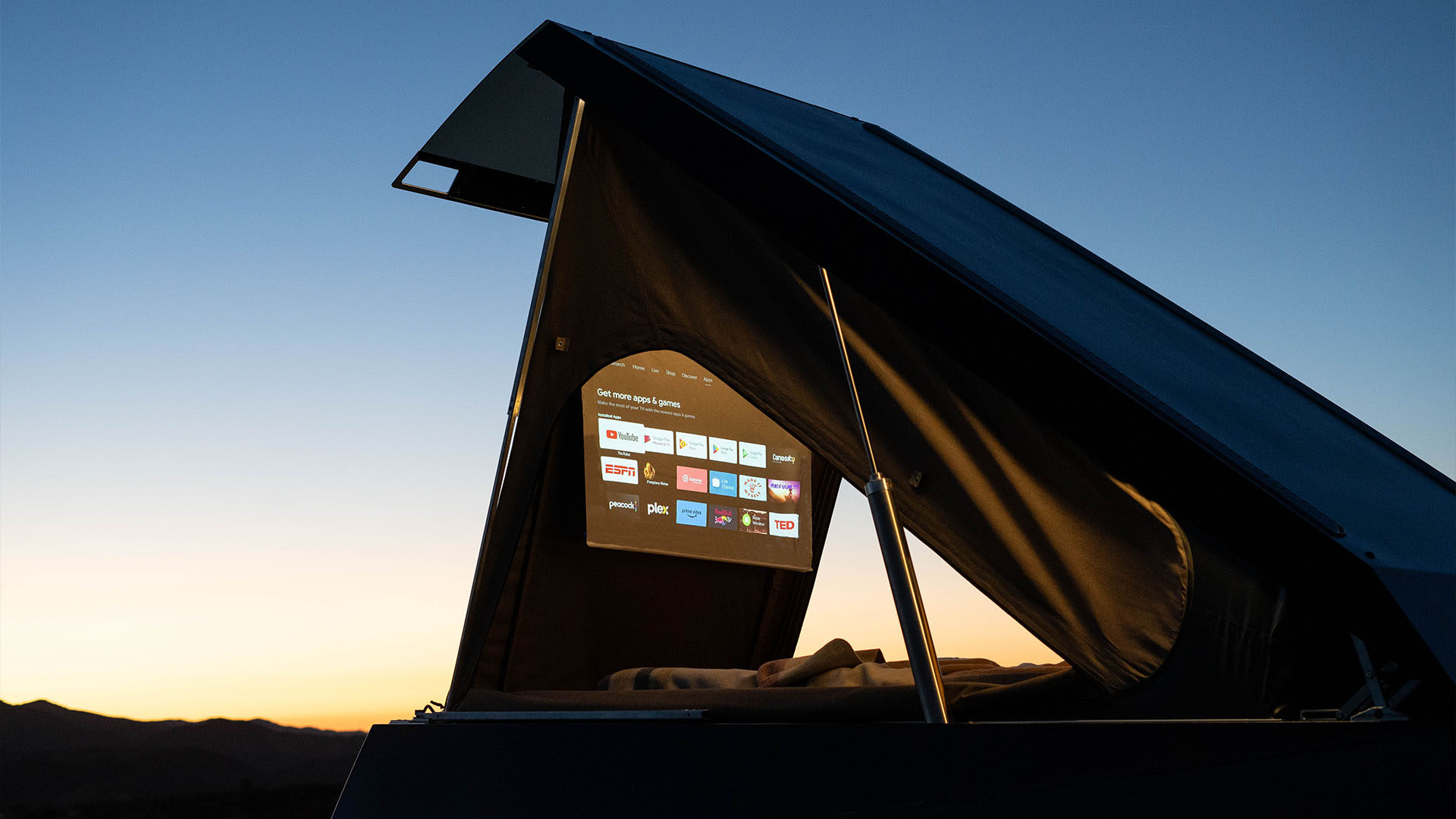 Projector casting on screen hanging from tent door