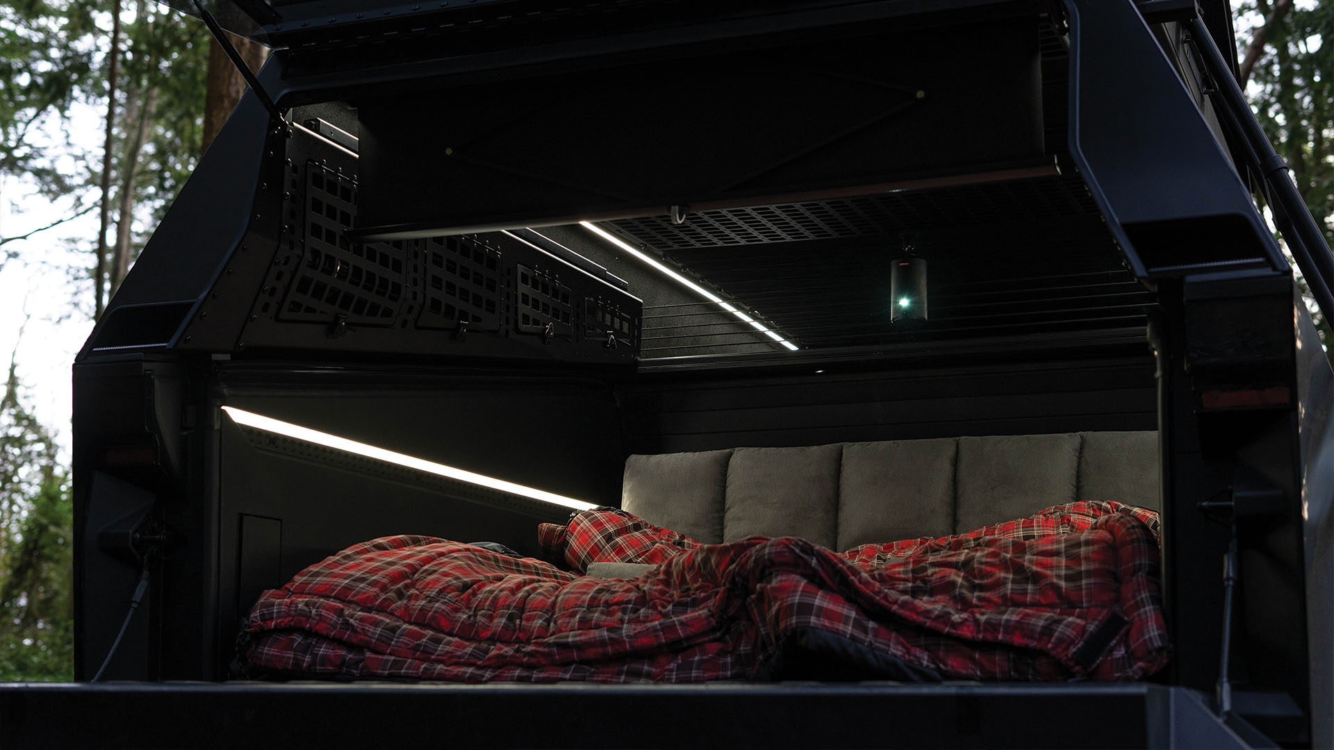 Camping in the back of the truck cap with projector playing on screen