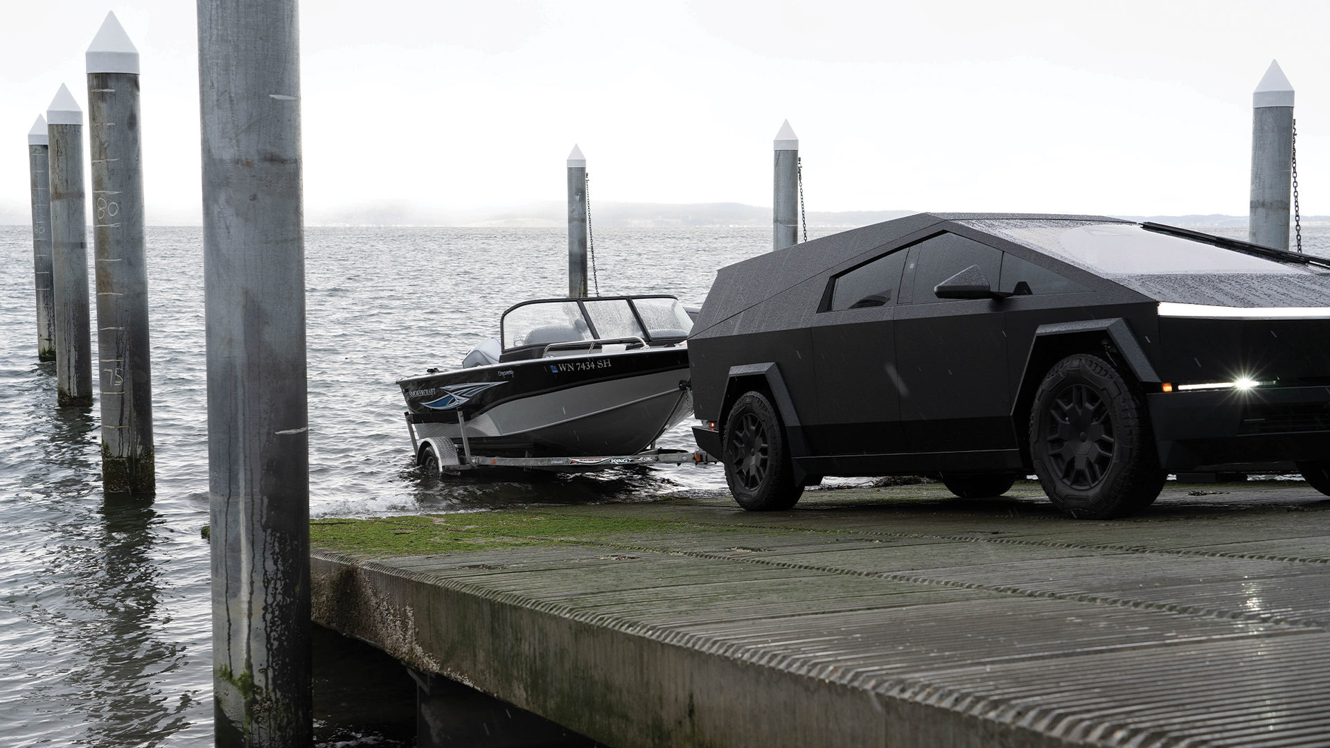 The Cybertruck towing a boat with Space Campers truck cap